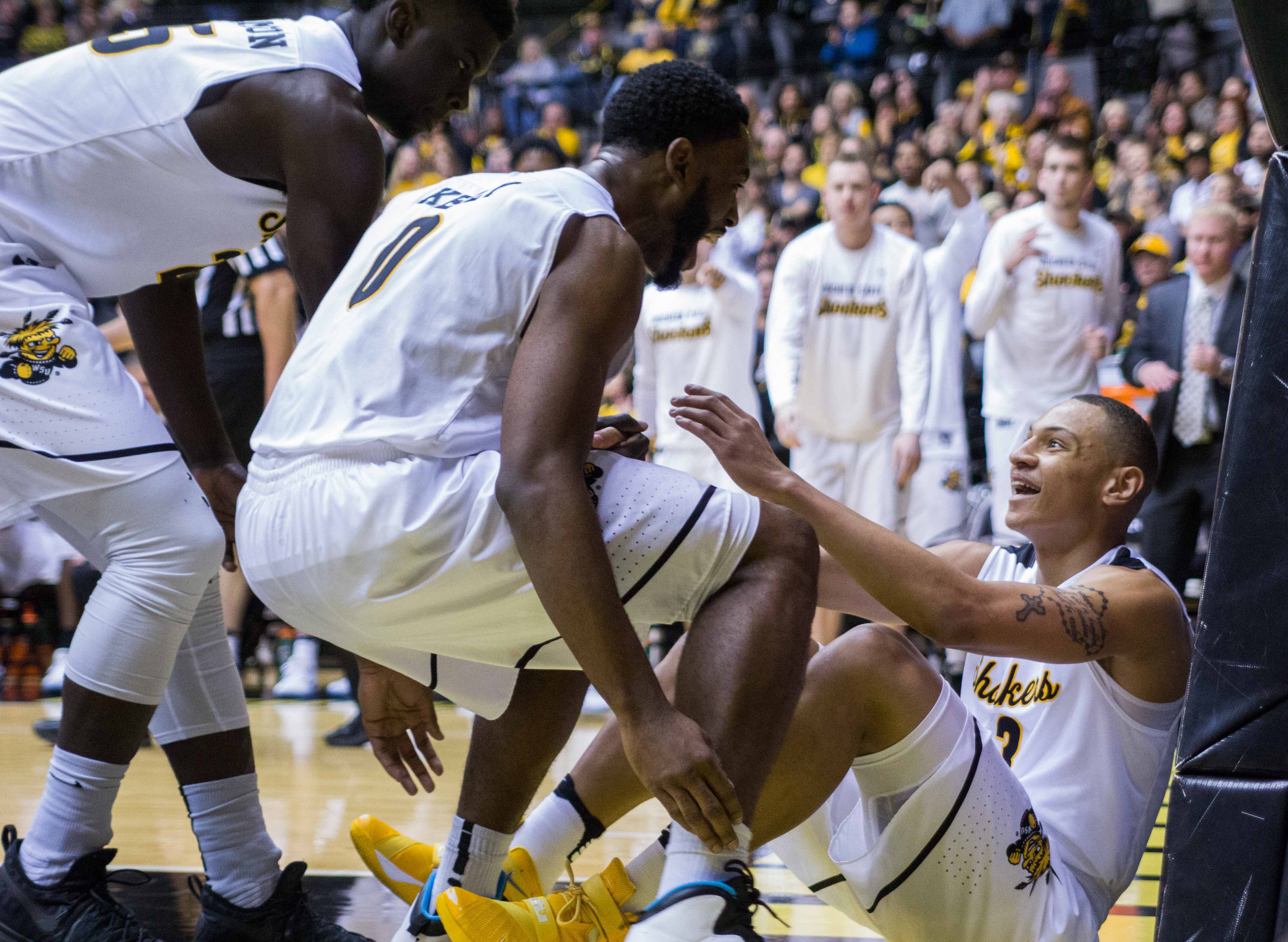 Teammates Eric Hamilton (25) and Rashard Kelly (0) help C.J. Keyser up after he is fouled making a shot on a drive to the basket.