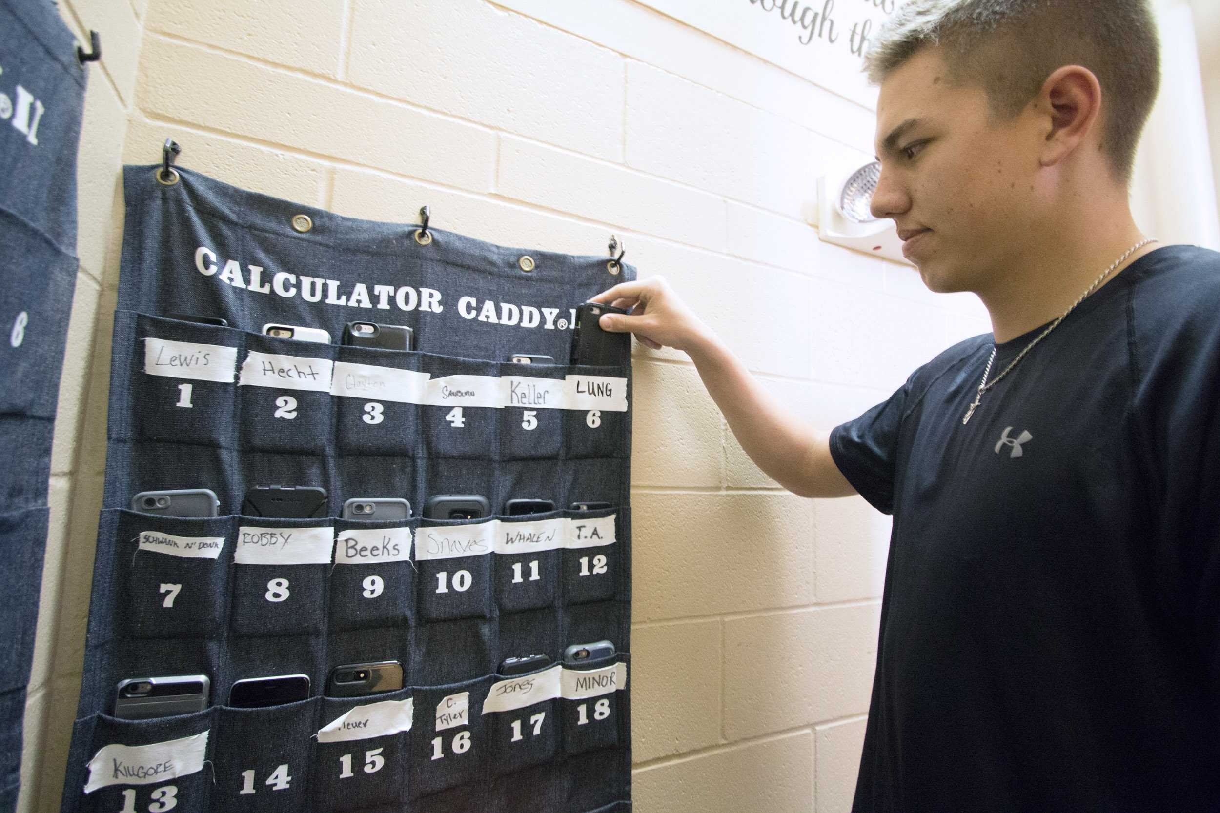 Connor Lungwitz places his phone in his designated slot before entering the locker room. Wichita State baseball coaches have implemented a no cell phone policy in the locker room.