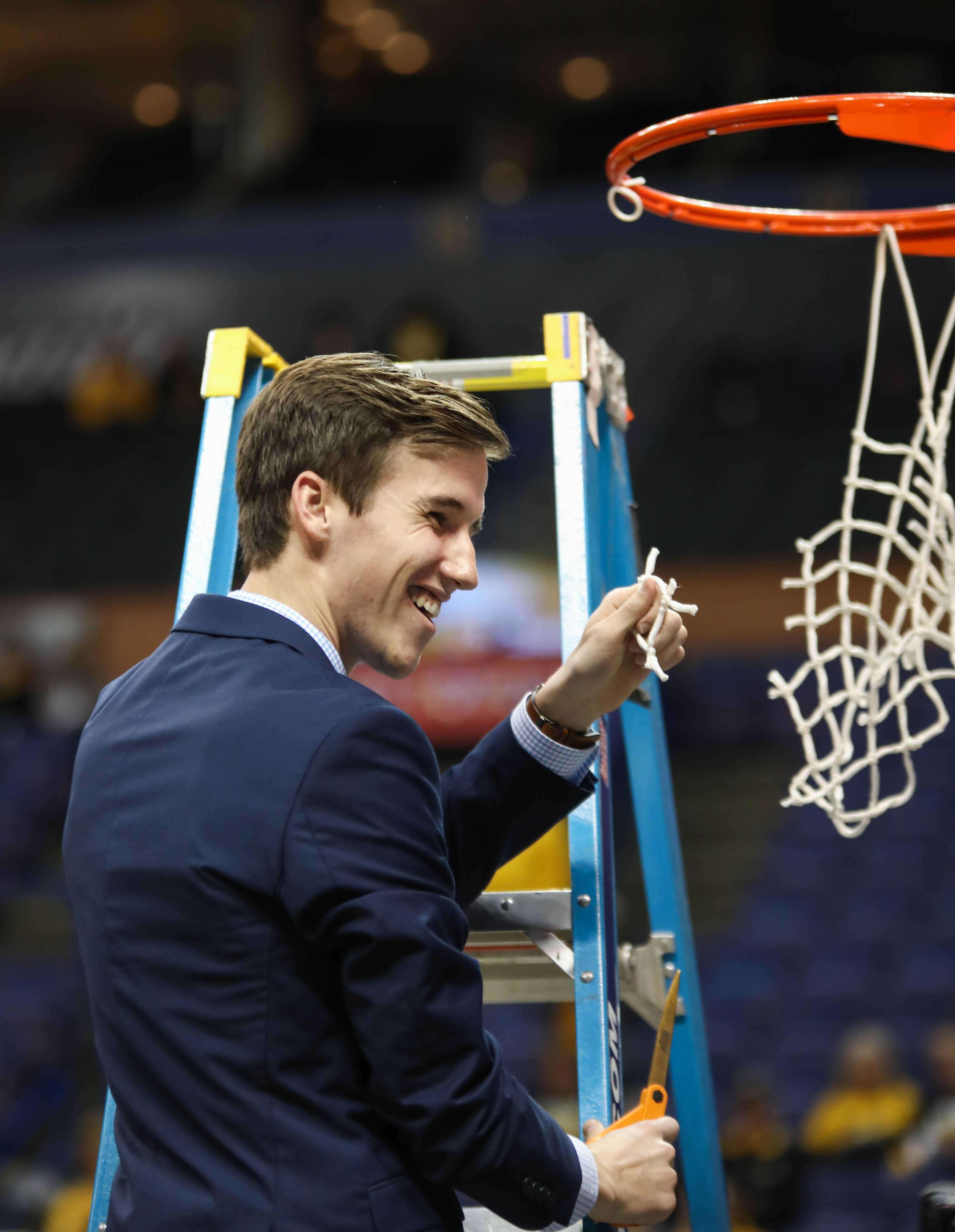 Kellen Marshall holds up his piece of the Missouri Valley Conference Tournament Championship net. Kellen is Gregg Marshall's son, and the head manager for the men's basketball team.