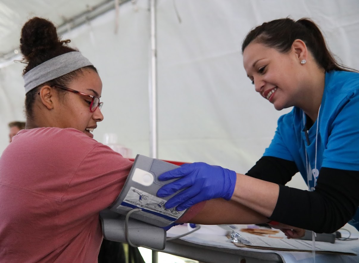 A volunteer checks the blood pressure of Kaesha Malcolm, 19, during Saturday’s day of free health care in Fairmount Park. Malcolm suffers from hypothyroidism.
Hypothyroidism is a deficiency of thyroid hormones. It can disrupt heart rate, body temperature and all aspects of metabolism.
Major symptoms include fatigue, cold sensitivity, dry skin, and unexplained weight gain.