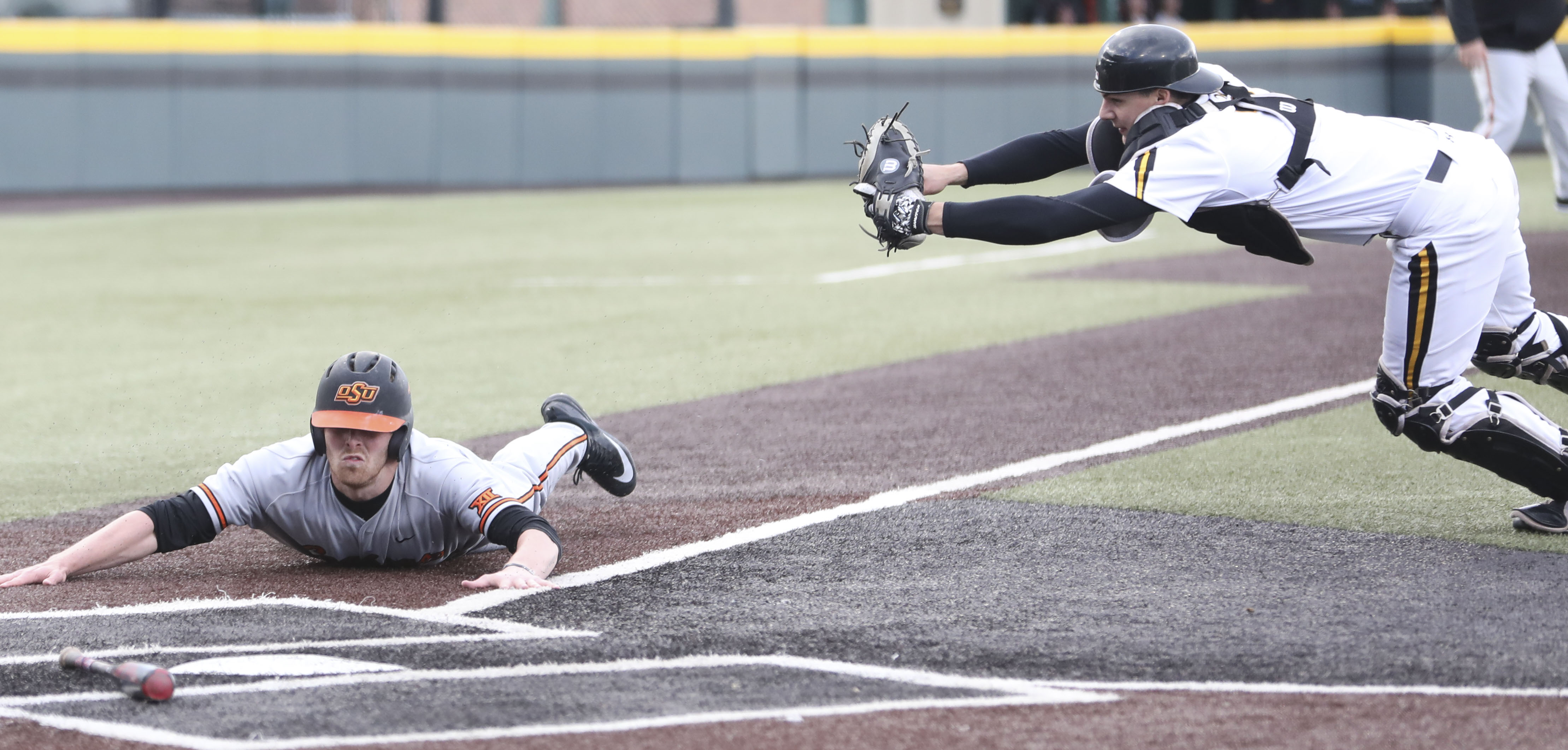 Oklahoma State infielder Cameron Dobbs scores against Wichita State catcher Noah Croft in the second inning during Wednesday's game in Eck Stadium. (April 5, 2017)