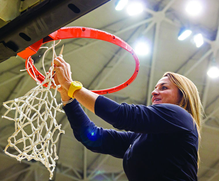 Wichita State womens basketball coach Jody Adams cuts down nets in Koch Arena during a pep rally on Wednesday. The rally was to celebrate the Shockers first conference title in school history.
