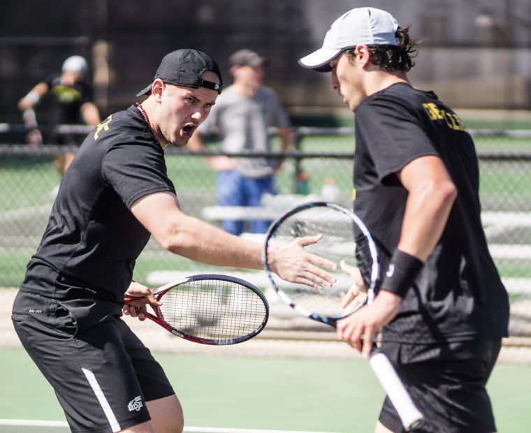 Senior Ilija Cuic high-fives his teammate Saturday afternoon inside the Sheldon Coleman Tennis Complex at WSU’s campus during his doubles-match. They won their doubles-match 8-7.