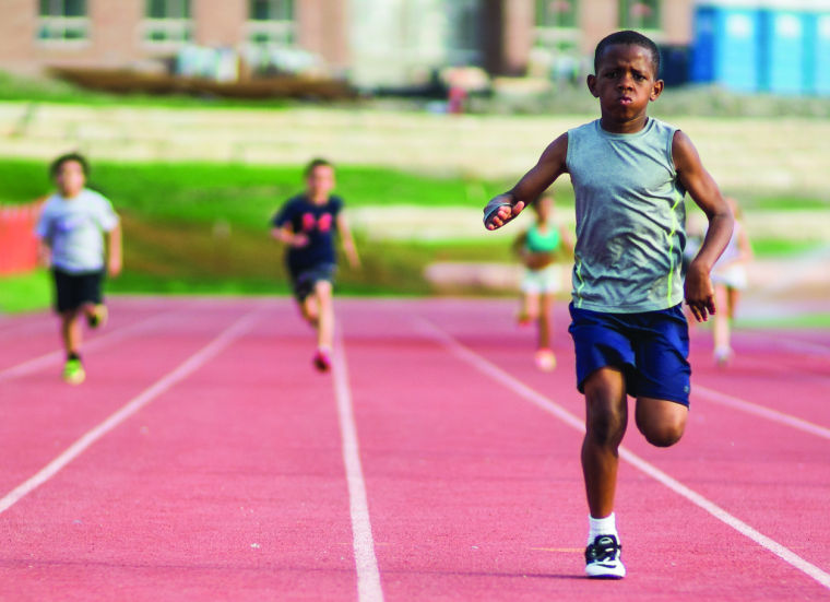 A child sprints toward the finish line during the Shocker Track Club Tuesday evening at Cessna Stadium. The Track club is hosted by Wichita State track students.