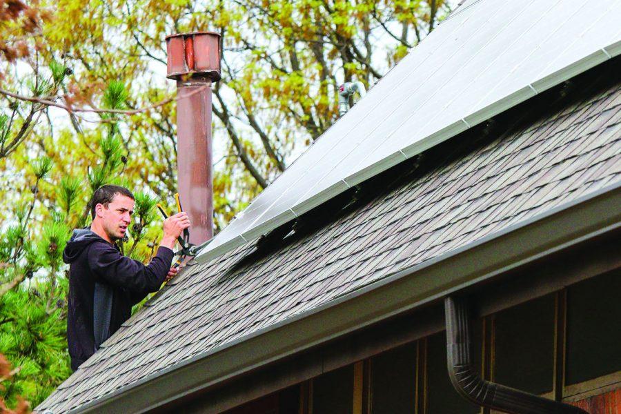 Mark Horst, employee with King Solar, updates solar panel equipment on the roof of University Methodist Church on April 14.