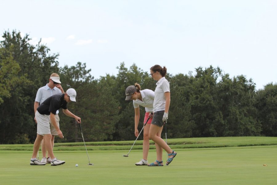 (From left to right) Juniors Austin Shelby, Jeff Sherman, Maggie Koops and Carley Larson read the green at hole three and prepare for their next shots at MacDonald Public Golf Course last Friday. Shelby, Sherman, Koops and Larson won the annual intramural golf tournament in their respective team brackets.