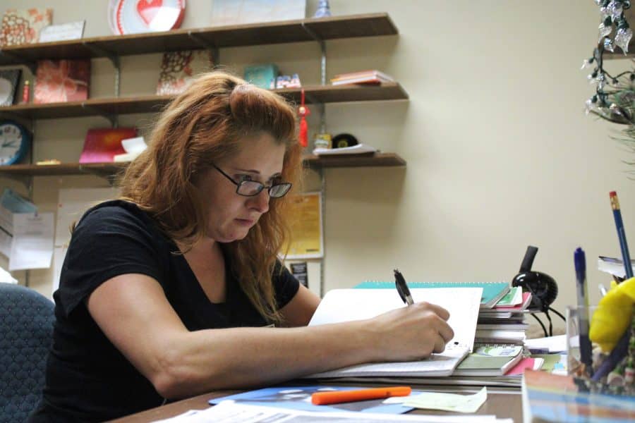 Krystal Iseminger, an English graduate teaching assistant from Fall 2015 to Spring 2017, grades paper at her desk. 