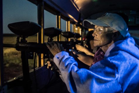 An attendant scouts the area for zombies to shoot with a paintball gun.