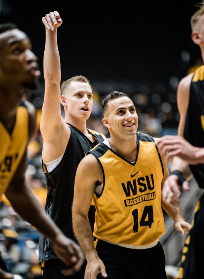 Senior John Robert “J.R” Simon, center, smiles after an attempted free-throw by Senior Zach Bush during Shocker Madness at Charles Koch Arena last Thursday.