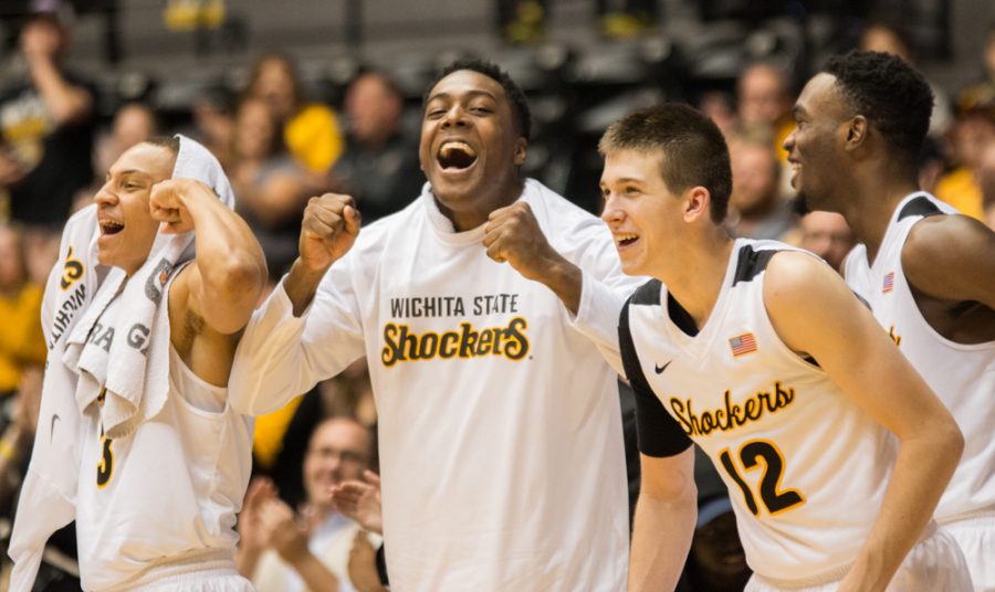 C.J. Keyser (3), Darral Willis Jr. and Austin Reaves (12) celebrate from the bench after Brett Barney makes a shot on a contested drive to the basket Sunday afternoon against Maryland Eastern Shore. Wichita State won the game 116-79.