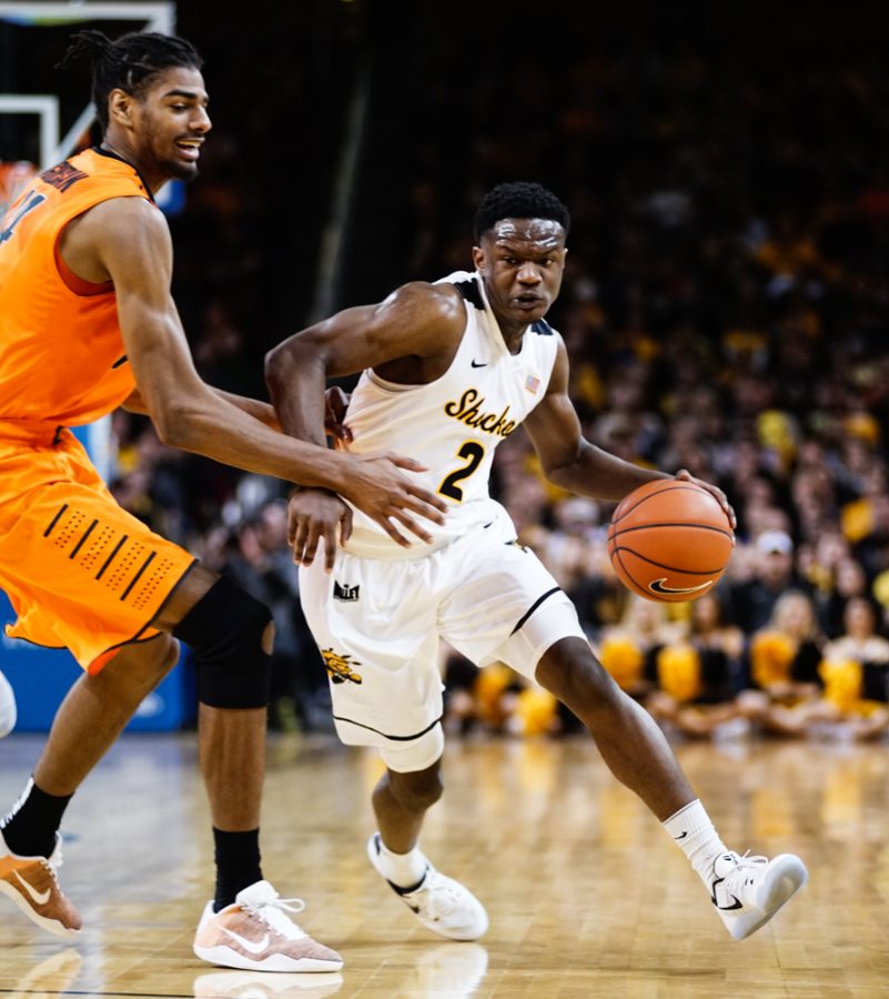 Junior guard Daishon Smith (2) drives to the paint against an OSU defender in the first half during the annual INSTRUST Bank Arena game Saturday evening. The Shockers fell to Oklahoma State by the score of 93-76.