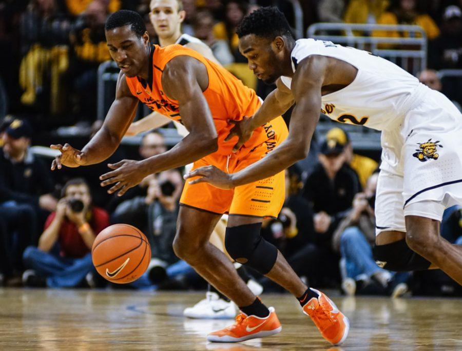 Sophomore forward Markis McDuffie (32) fights for the lose ball against an OSU defender in the second half of the annual INSTRUST Bank Arena game Saturday evening. 