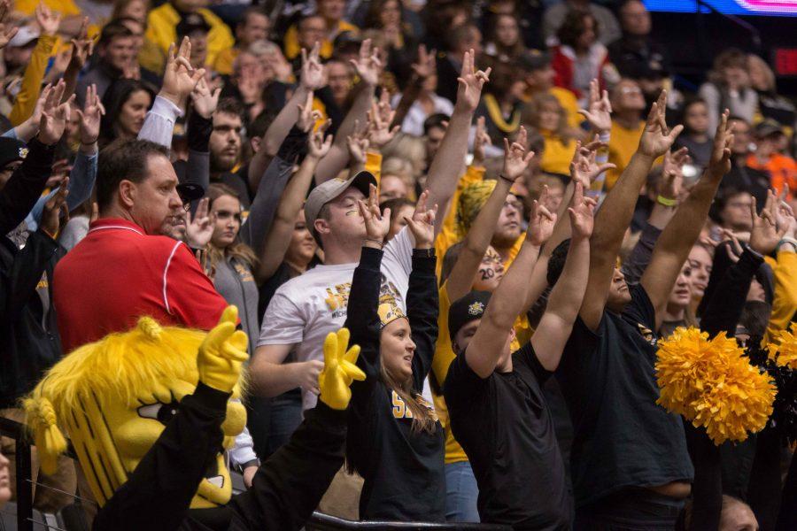 Fans raise their hands in the air as a Wichita State player takes a free throw shot Tuesday night in Charles Koch Arena.