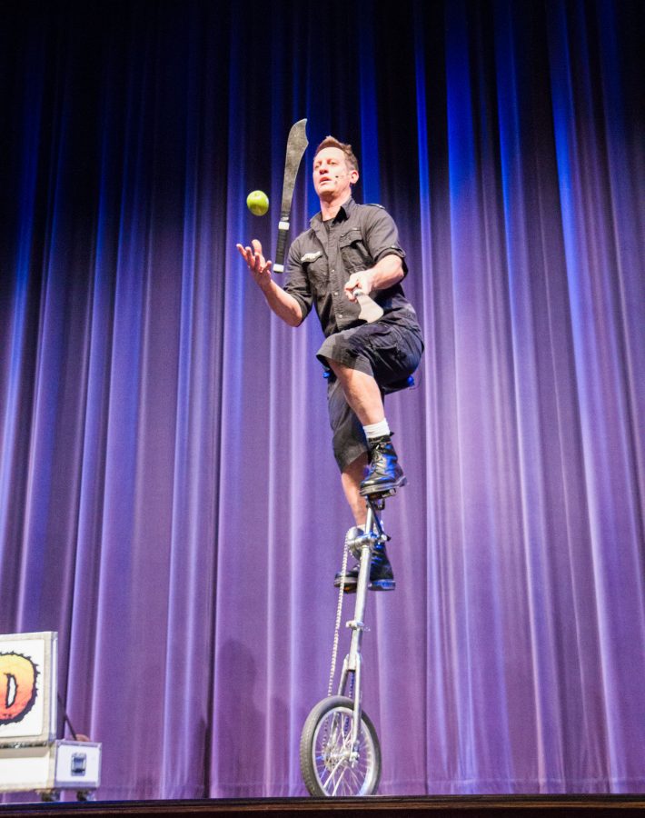 Mad Chad juggles two knives and an apple while riding a unicycle during his show at the CAC Theater Saturday night.