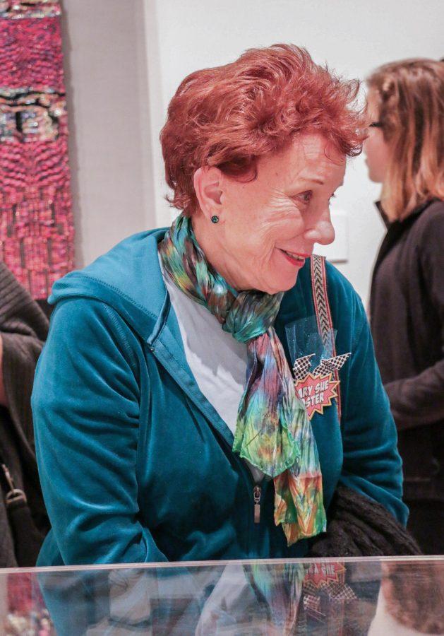 Mary Sue Foster, WSU professor, chats with spectators during the Ulrich opening on Saturday. Foster has multiple pieces currently on display in the gallery.