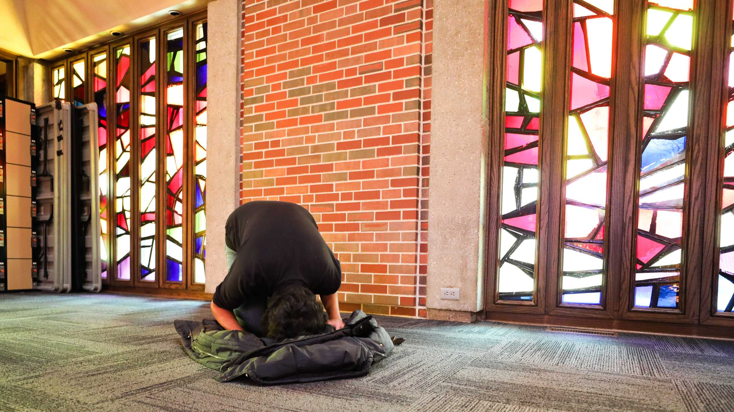 Danial Imran uses his jacket as a prayer mat while doing the Asr prayer in the Interfaith Prayer space on Wednesday. (Feb. 8, 2017)