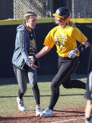 Injured pitcher Jenni Brooks cheers on Ryleigh Buck after she hits a homer in the scrimmage on Feb. 7, 2017. Brooks coached third base during the scrimmage. Brooks has continued to find ways to be involved with the team despite her injury.