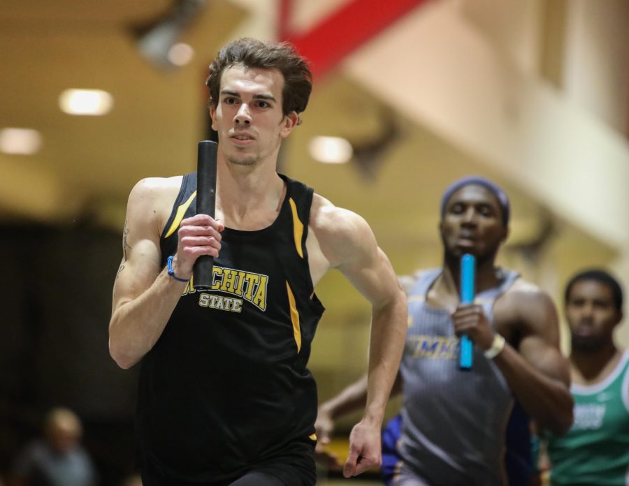 Cody Scheck runs the 4 by 400 meter relay at the Herm Wilson Invitational in the Heskett Center.