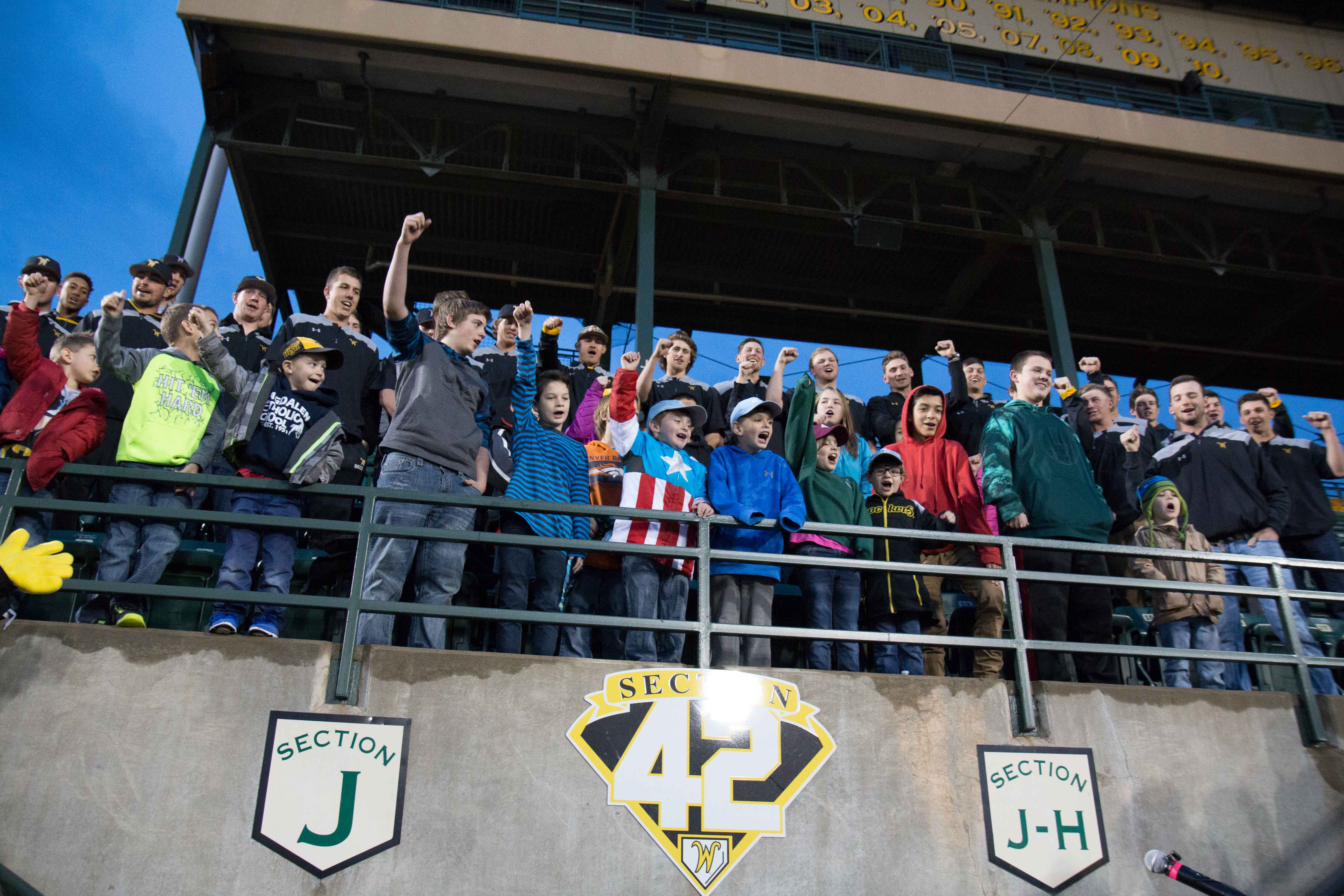 Wichita State's baseball team and members of League 42, a Wichita youth baseball league, cheer for the opening of Section 42. Section 42 is a special section of seating for members of League 42.