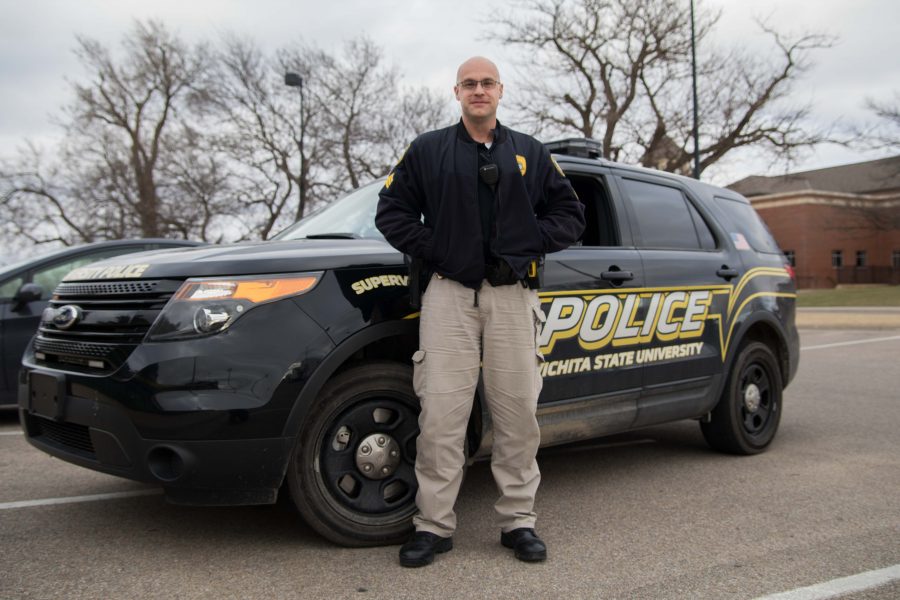 Garrett Moyer, a former sergeant with the WSU police department, poses with a police vehicle. Moyer was fired in August 2017 and is now suing WSU for discrimination and retaliation.