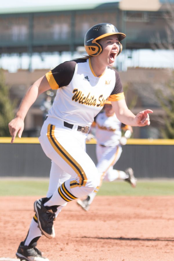 Junior Mackenzie Wright cheers as she races to home base to score against Drake. 