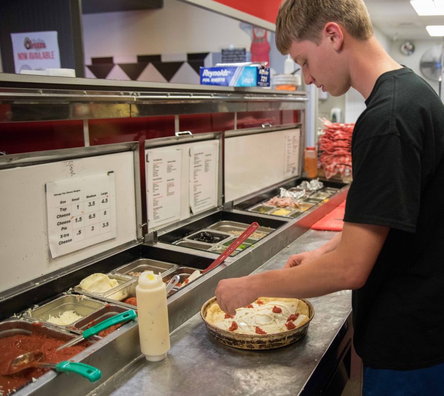 Cole Buckingham makes a cheeseburger pan pizza on Tuesday evening in Knolla’s Pizza’s east location at Central and Oliver. Knolla’s Pizza first opened in Orlando, Florida in 1981 then came to Wichita in 1988.