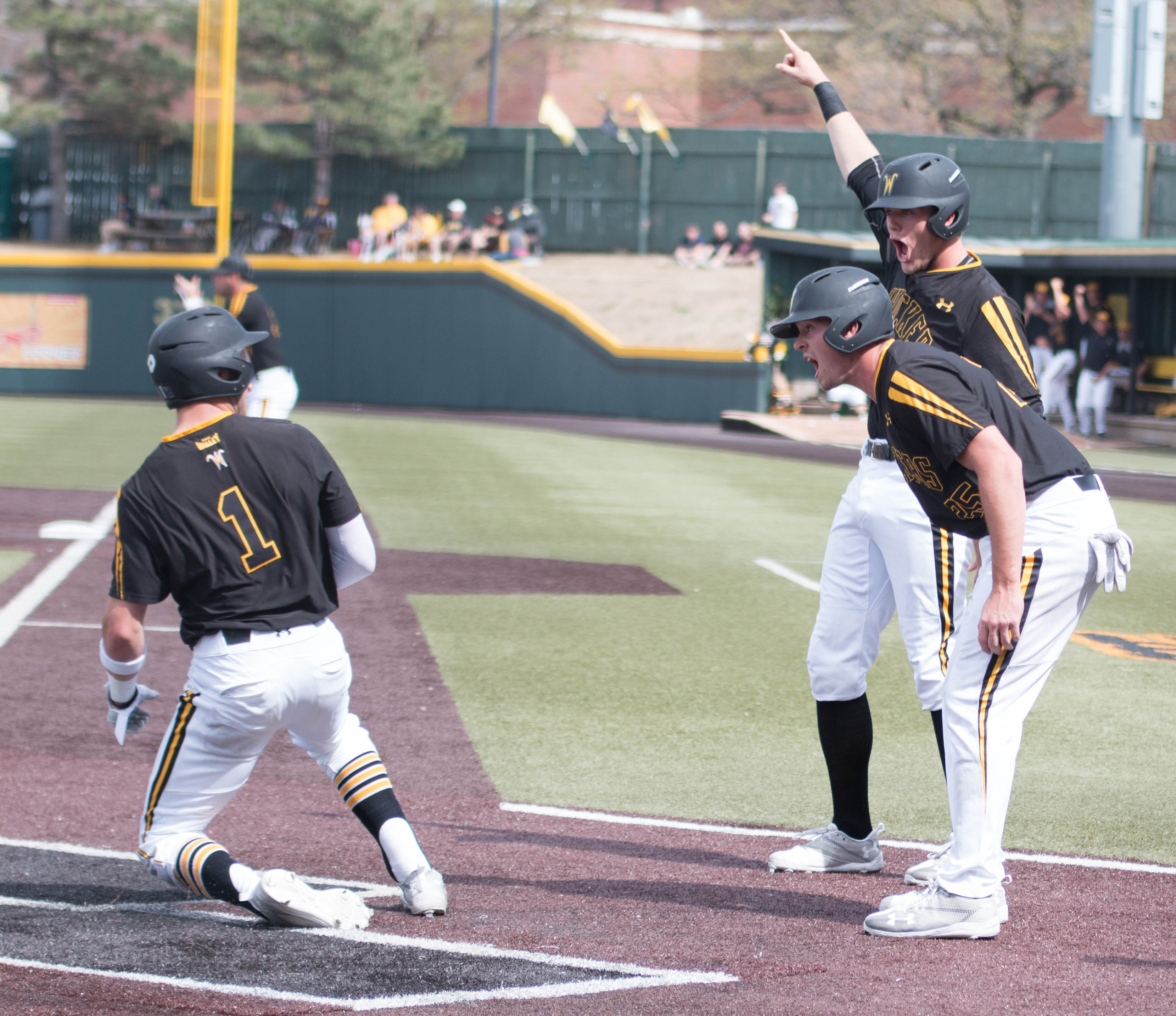 Greyson Jenista and Dayton Dugas meet Travis Young at home plate after scoring against Southern Illinois. (File photo)