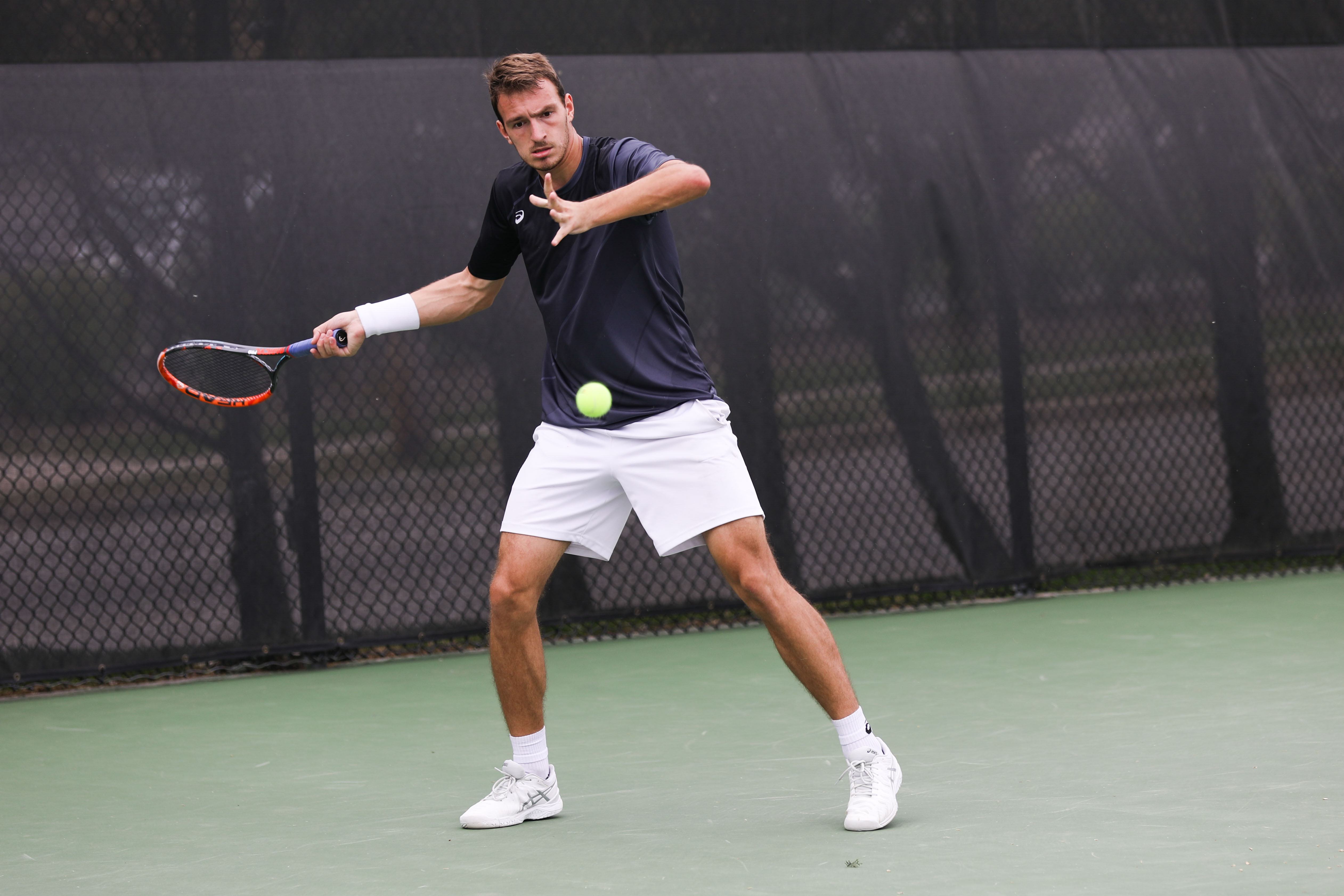 Wichita State player Miroslav Herzan attempts to return a serve during Saturday’s match in the Coleman Tennis Complex. (Apr. 9, 2017)
