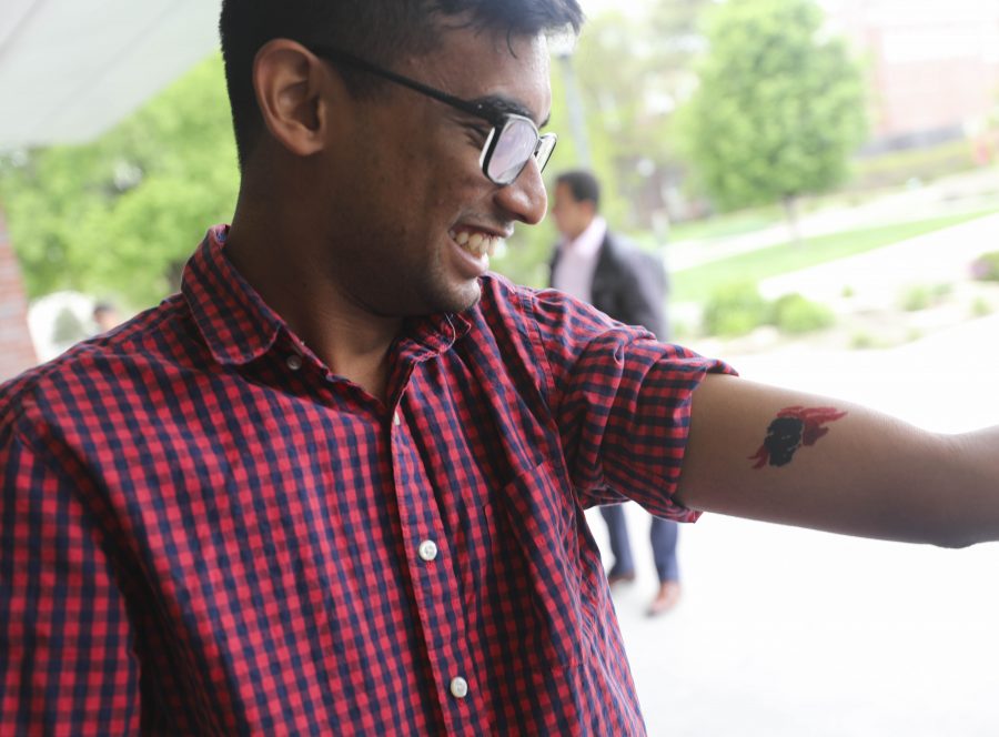 Harry Vasagar smiles after getting his second temporary tattoo during the TOMS One Day Without Shoes event on the north patio of the RSC, on Wednesday.