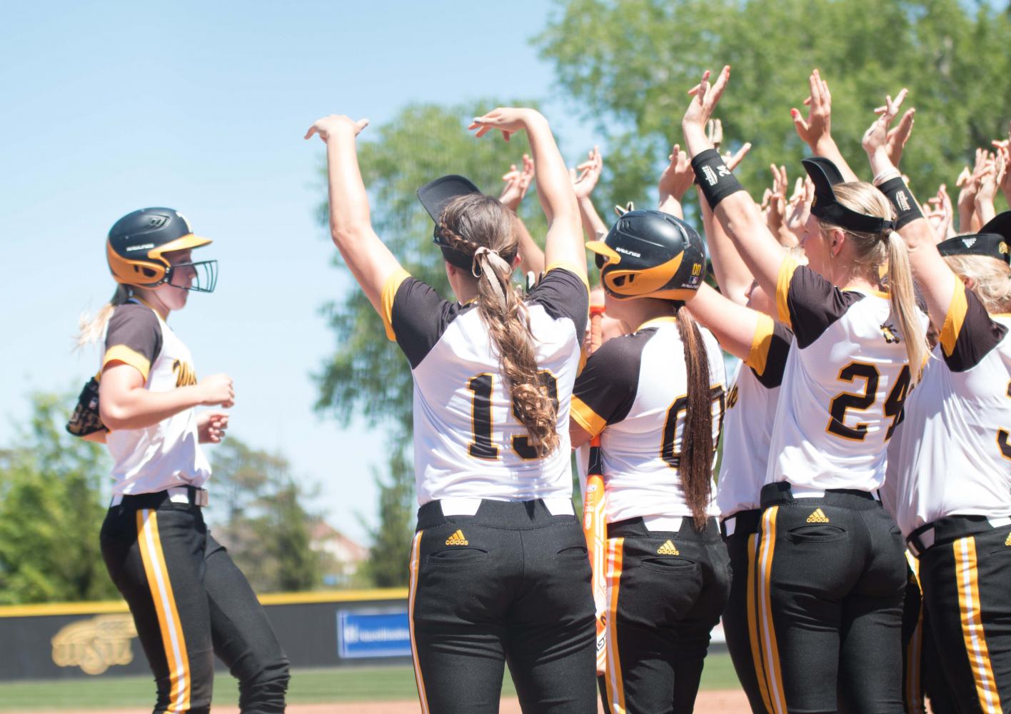 Members of the Shocker softball team greet sophomore Laurie Derrico after a home run against Evansville.