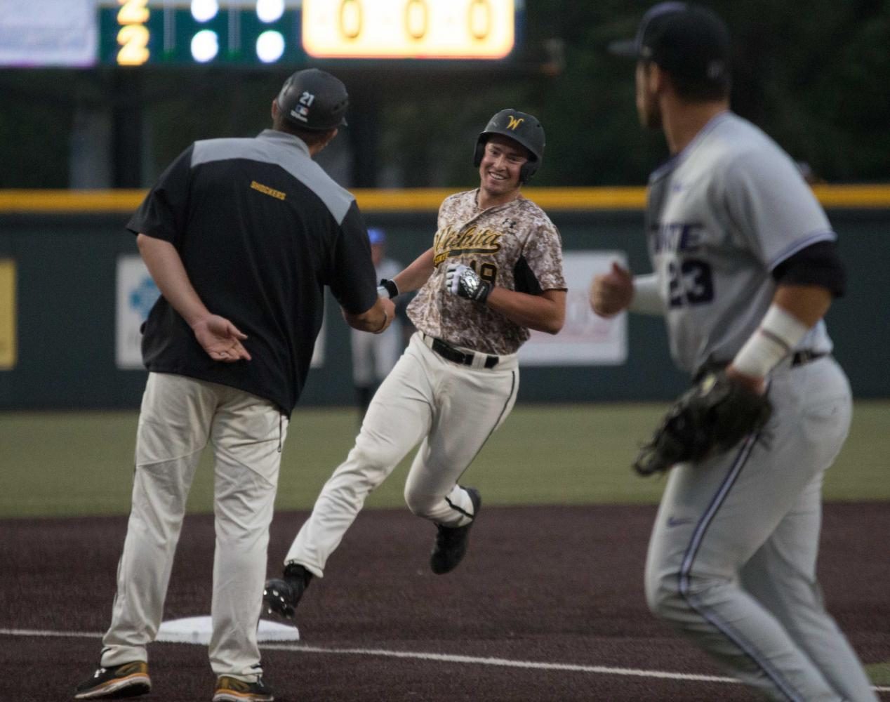Wichita+State+sophomore+Luke+Ritter+smiles+at+assistant+coach+Brian+Walker+after+hitting+a+walk-off+home+run+to+beat+K-State+3-2+Tuesday+evening+at+Eck+Stadium.