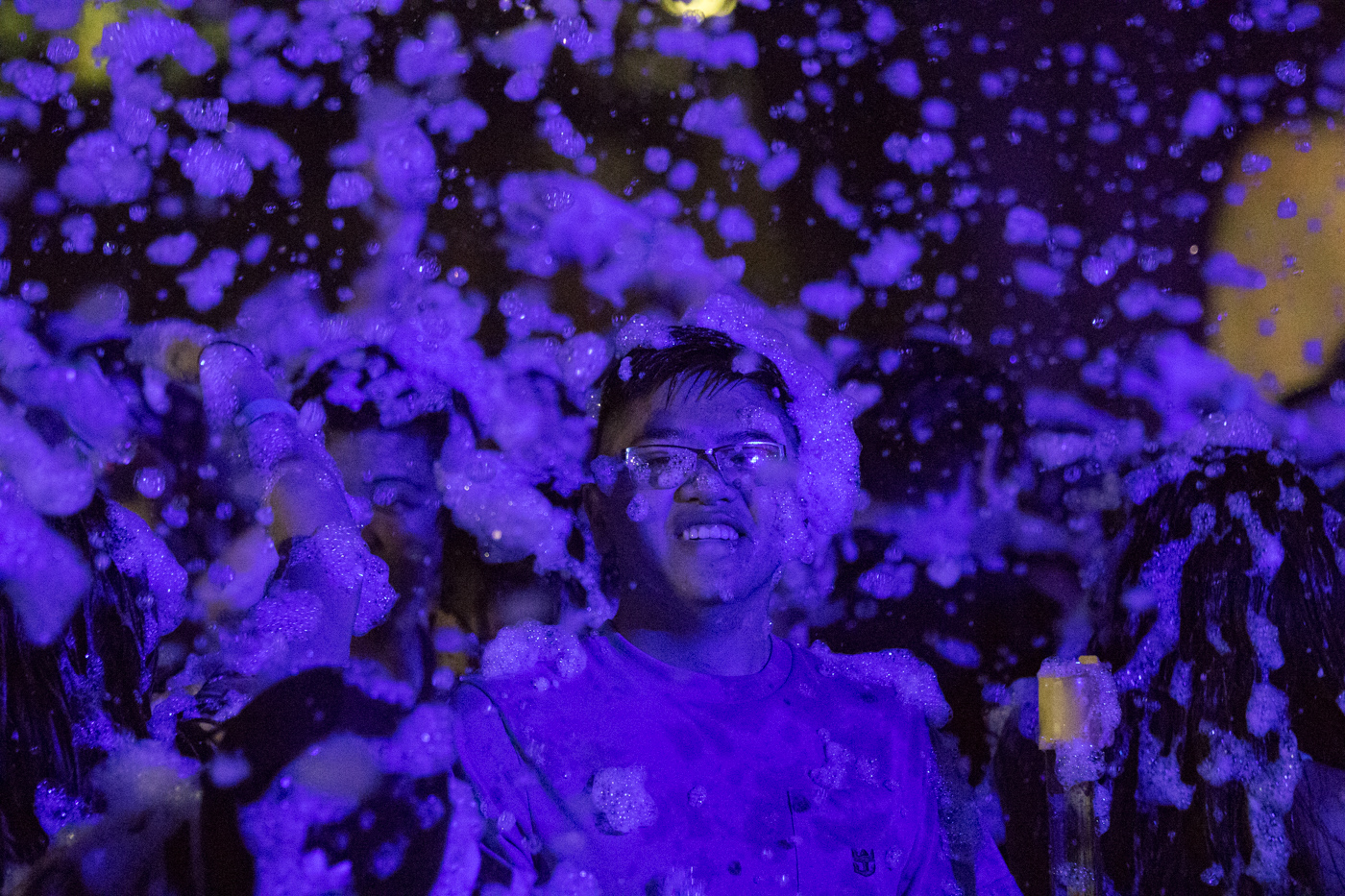 The foam is falling down while students smile from cheek to cheek.