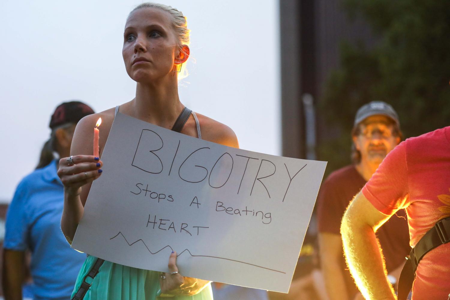 A+supporter+holds+a+candle+and+a+sign+during+the+rally+for+solidarity+in+Wichita.+%28Aug.+13%2C+2017%29%0A