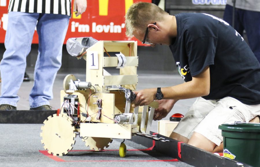 A student works on their robot at the robotic competition at Koch Arena.