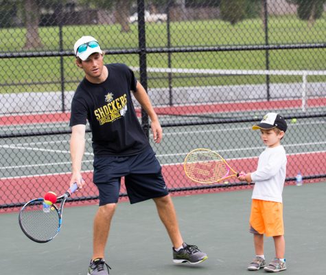Coach Colin Foster plays tennis with a youth at the free clinic. (File photo)