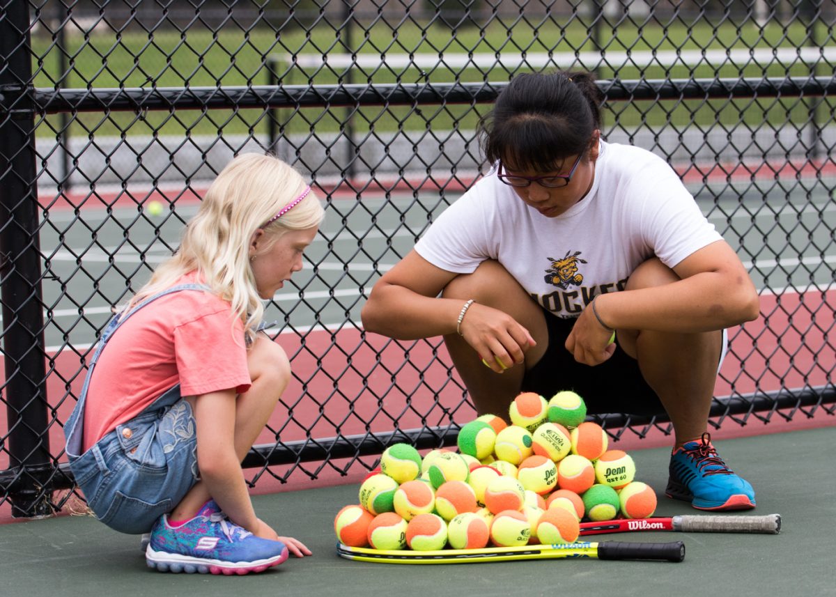 Ting-Ya Hsu picks up balls and talks with a youth during the free clinic held at the new courts in Fairmount Park in August