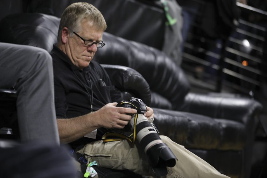 Jeff Tuttle looks at photos on the back of his camera during the Shockers vs. Newman.