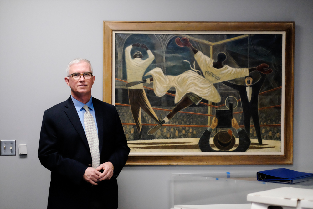 Bob Workman with one of his favorite paintings, Fletcher Martin's
