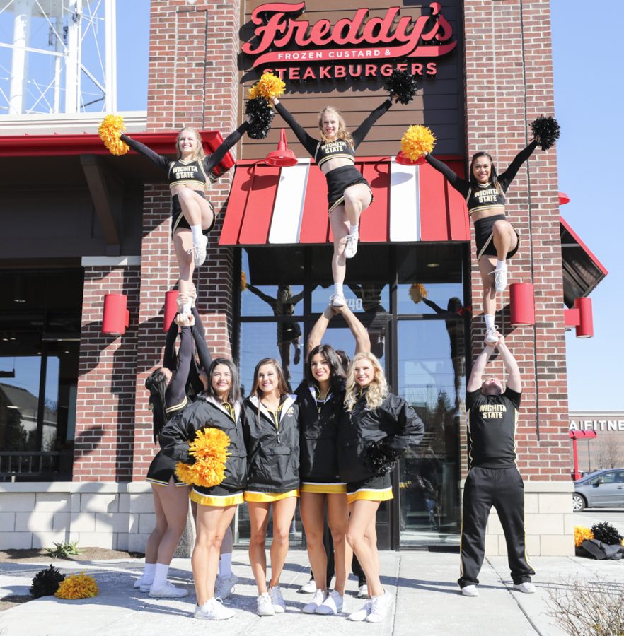 The Wichita State cheerleading team stunts outside of a Freddys Frozen Custard & Steakburgers.