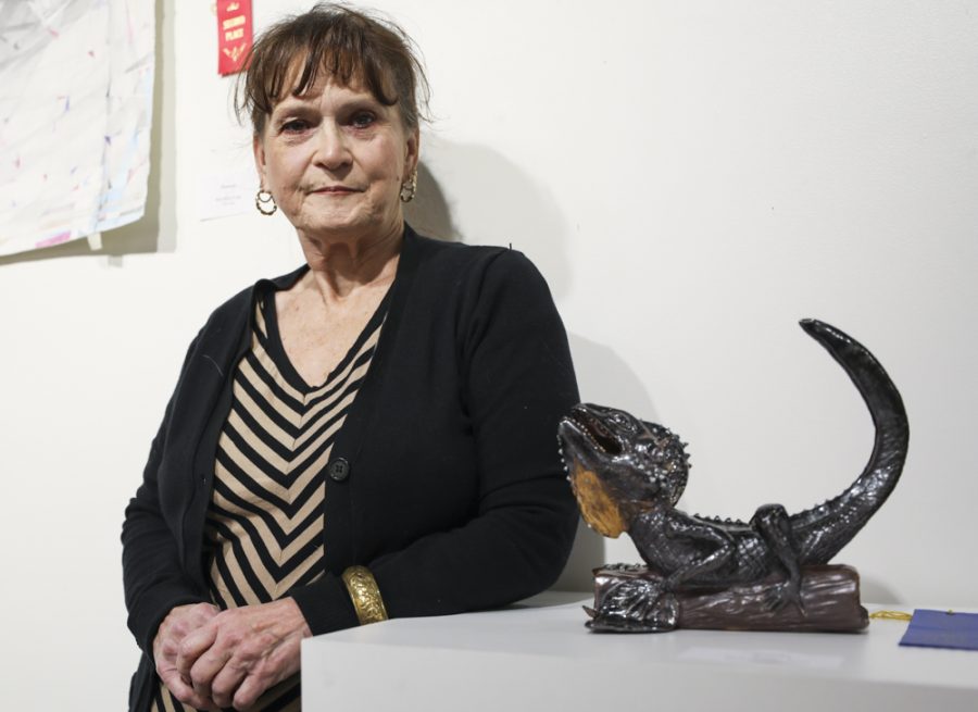 Kathy Robb stands next to her ceramic sculpture, Struttin, in the Cadman Art Gallery. Struttin won first place in the element student art contest.