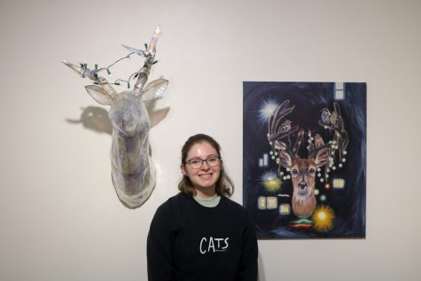 Theresa Wolf poses in front of her work, New Catch and Urban Outgrowth, in the Cadman Art Gallery.