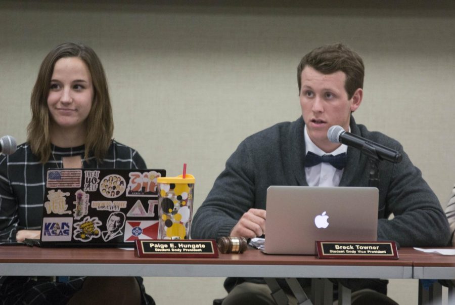 Breck Towner, student body vice president, speaks to a senator during the meeting Wednesday evening.