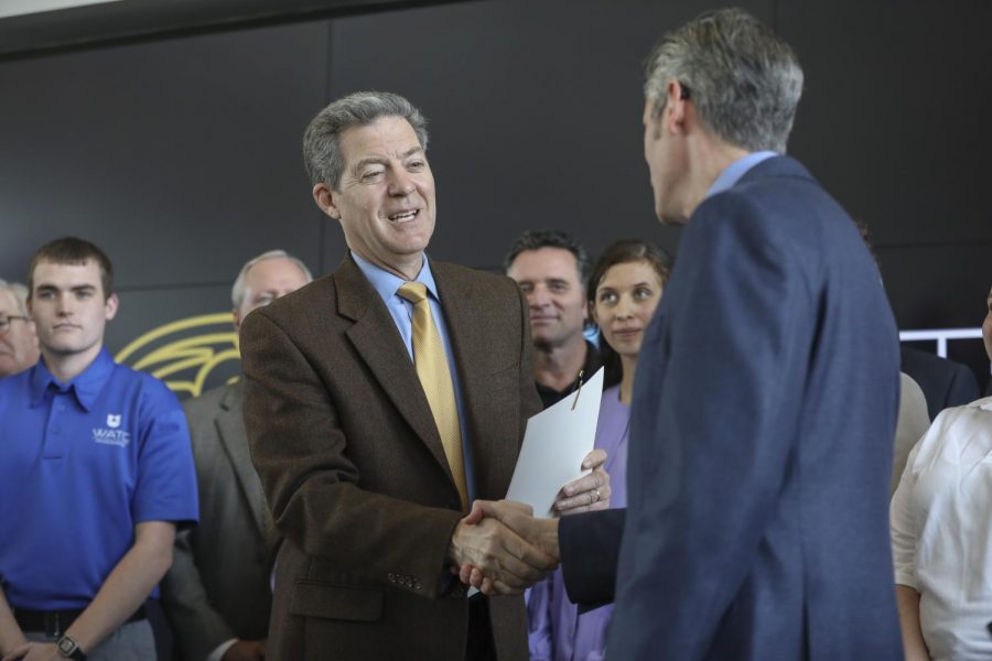 Sam Brownback shakes interim-Provost Rick Mumas hand at the Experiential Engineering building on Innovation Campus last spring. Brownback was confirmed as ambassador-at-large for international religious freedom. 