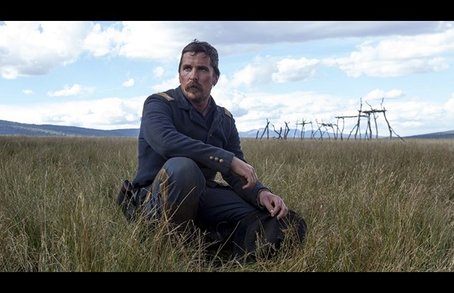 Christian Bale kneels in a scene from Hostiles.