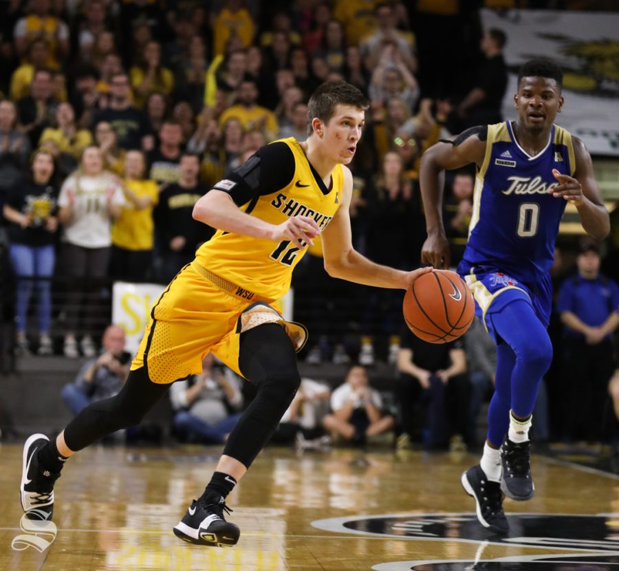 Wichita State guard Austin Reaves drives to the basket down court around Tulsa forward Junior Etou during the second half at Koch Arena.