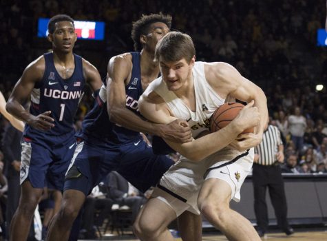 Wichita States Asbjørn Midtgaard fights over a loose ball against UConn defenders Saturday night at Koch Arena.