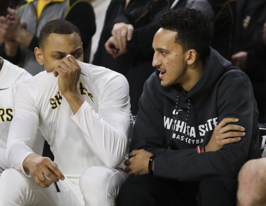 Wichita State guard C.J. Keyser covers his mouth as Wichita State guard Landry Shamet talks before tipoff against the Tulane Green Wave at Koch Arena. Shamet did not suit up.