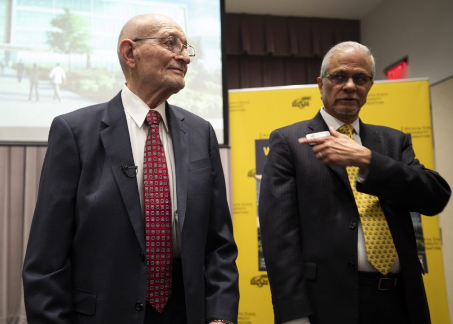 Wayne Woolsey and Dean of the School of Business Anand Desai wait to take photos with the rendering of the new building which will be the future home of the Barton School of Business.