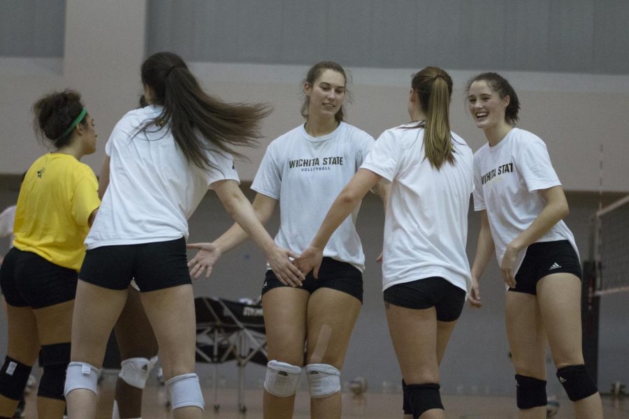 Wichita State volleyball players celebrate after completing a successful play during practice in Koch Arena. 