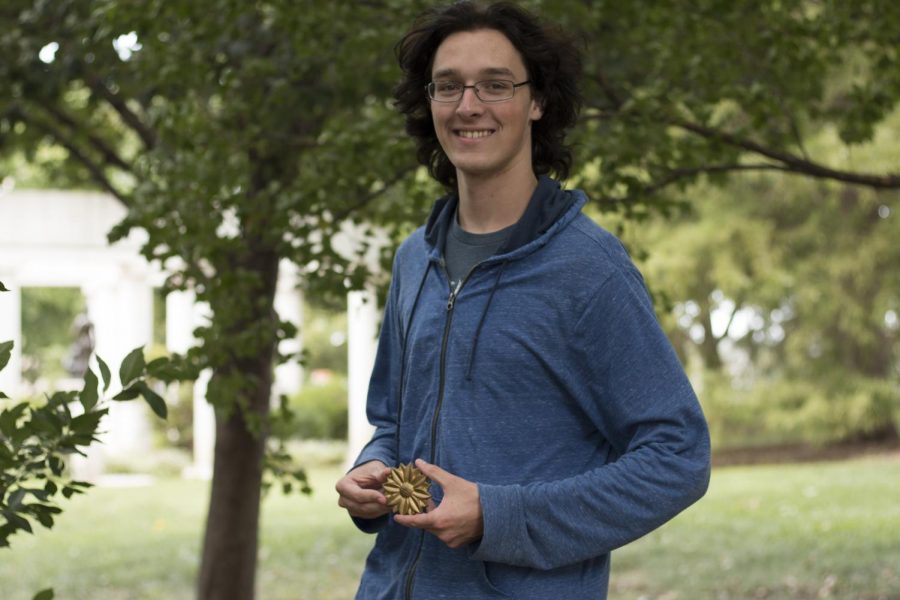 Christian Hurst, graphic design sophomore, poses with The Sunflowers medallion. He found it around noon Friday, Aug. 21, 2018.